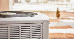 Residential air conditioning unit with snow in winter. 
