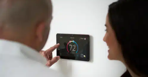 Man checking thermostat with a woman